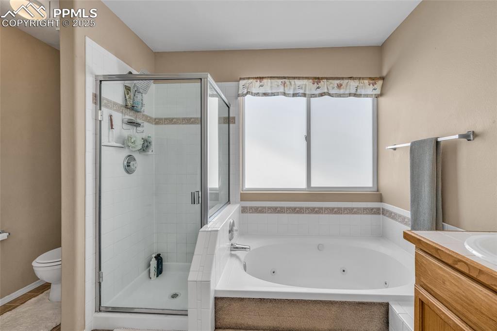 Image 17 of 40: Full bath with vanity, a whirlpool tub, and a stall shower