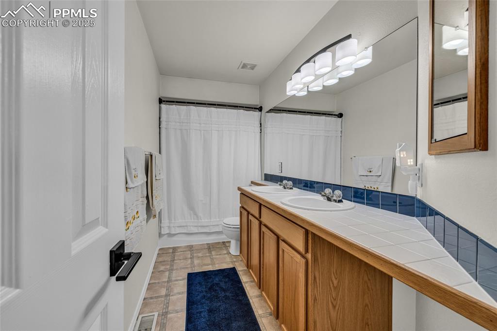 Image 19 of 40: Full bathroom featuring double vanity and shower / tub combo