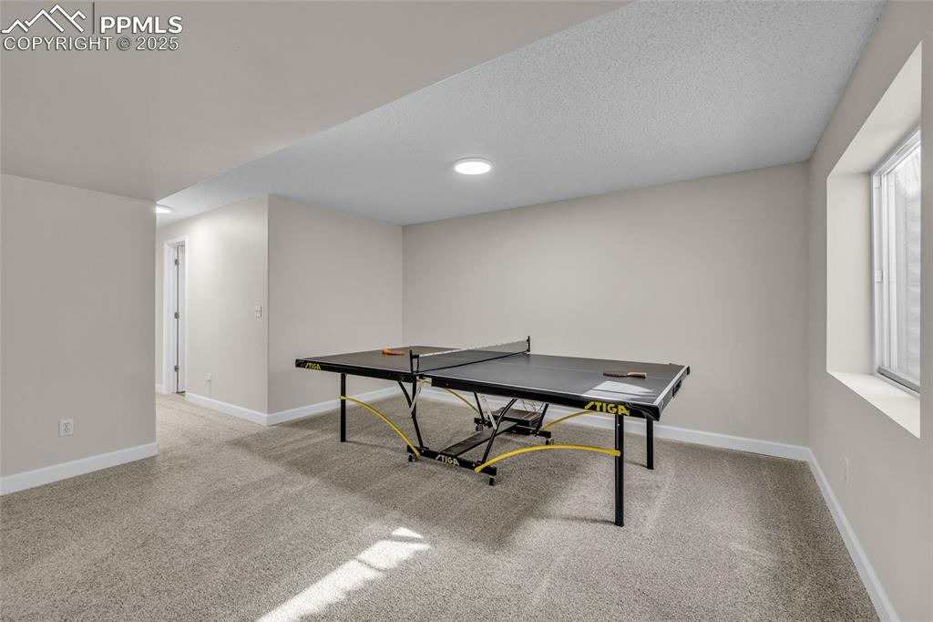 Image 25 of 40: Game room featuring light colored carpet and a textured ceiling