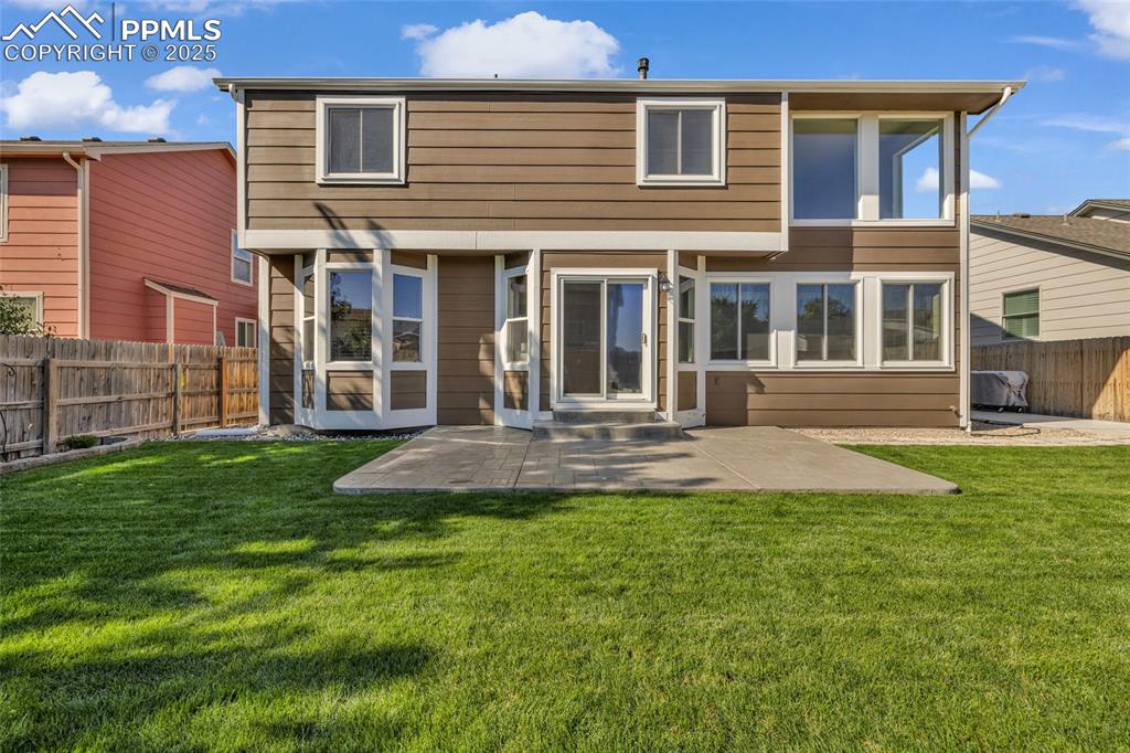 Image 32 of 40: Back of house featuring a patio area, a fenced backyard, and a sunroom