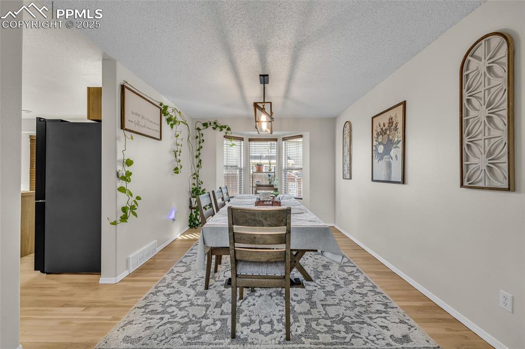 Image 5 of 40: Dining room featuring a textured ceiling and light wood-style flooring