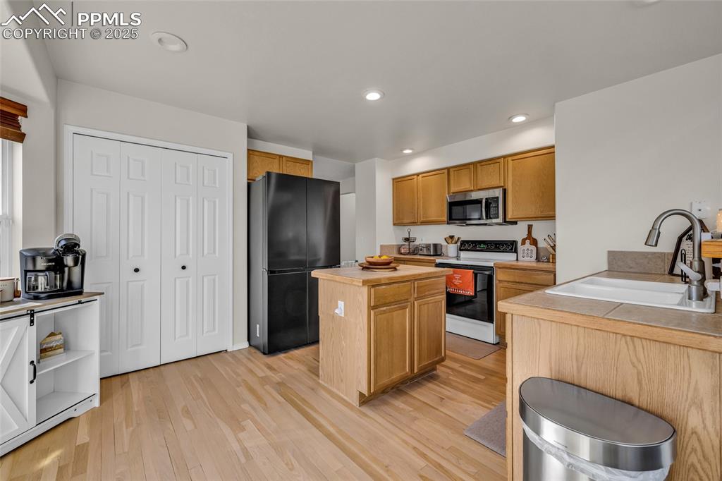 Image 9 of 40: Kitchen featuring range with electric stovetop, recessed lighting, light co