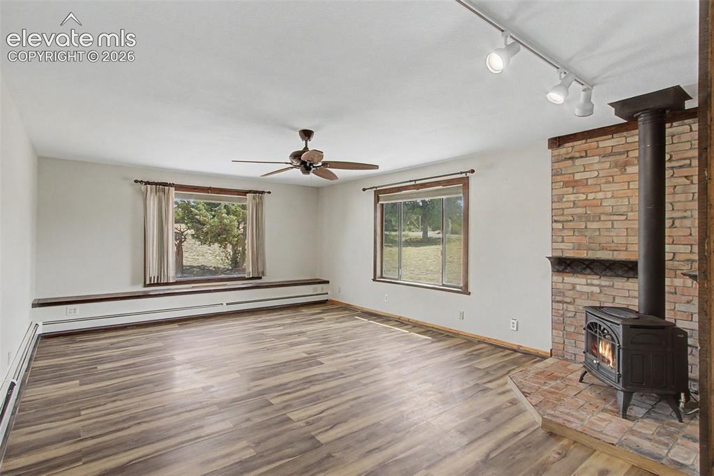 Image 17 of 50: Large family room with big picture window, built-in benches w/ storage, and