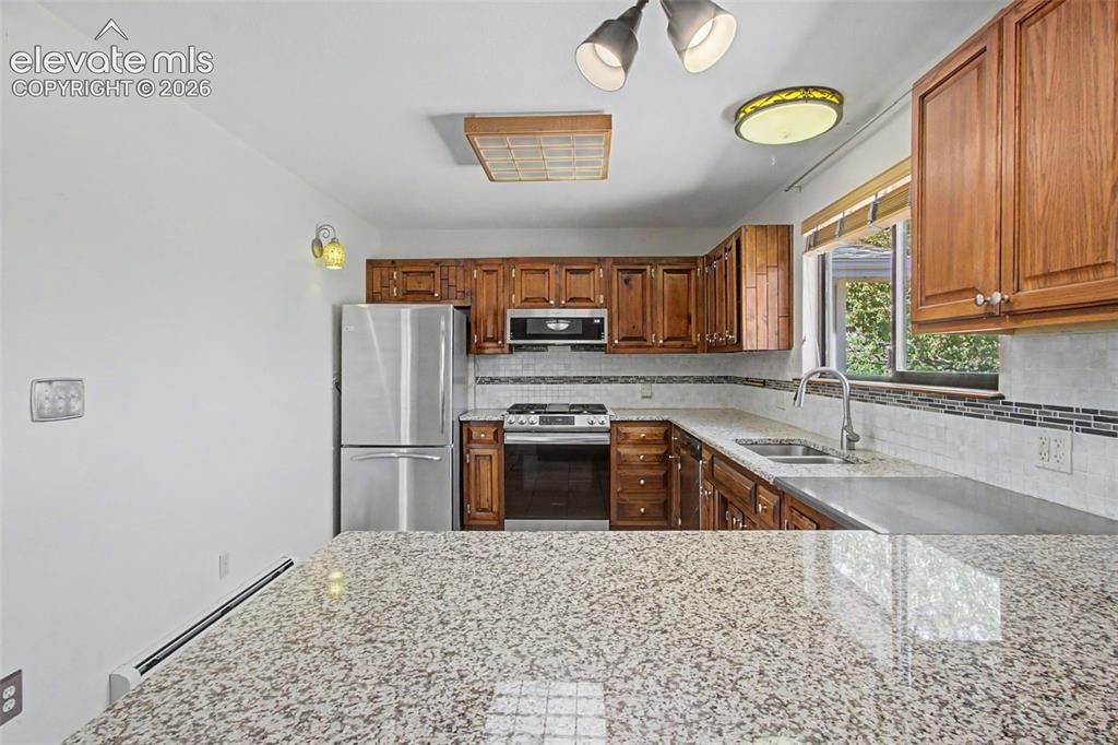 Image 22 of 50: Spacious kitchen with tile floor, natural gas range, granite counters, and