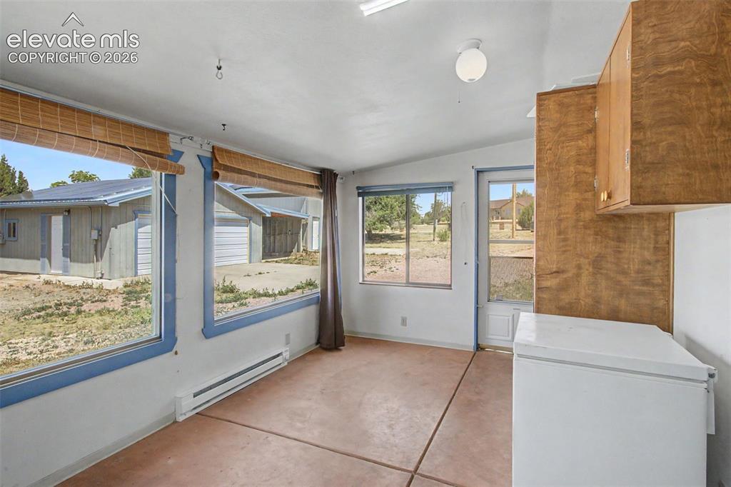 Image 23 of 50: Finished sunroom with sunset-watching picture windows, heat, and A/C.