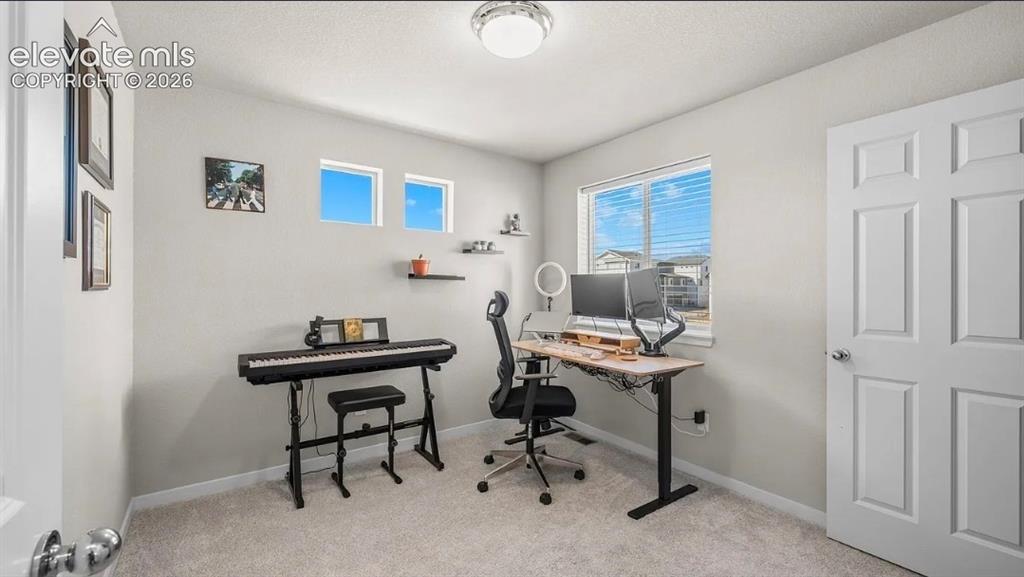 Image 11 of 22: Dedicated home office featuring dual workstations with adjustable-height de