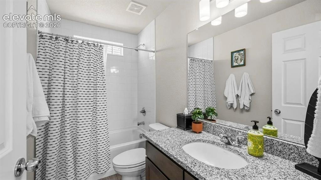 Image 12 of 22: Spa-inspired bathroom featuring dual vanities with speckled stone counterto