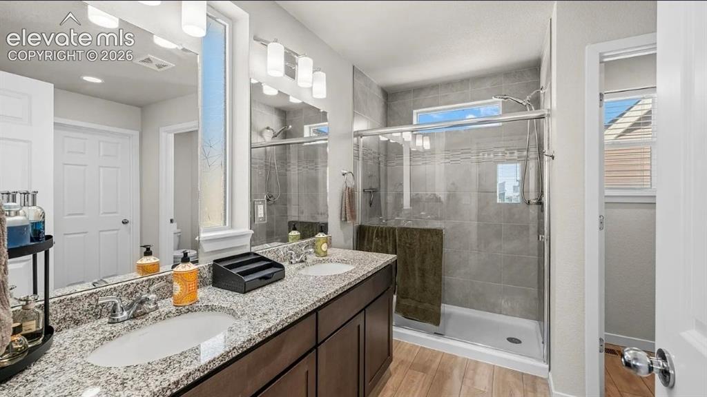 Image 19 of 22: Spa-inspired primary bathroom featuring a dual-sink vanity with speckled st