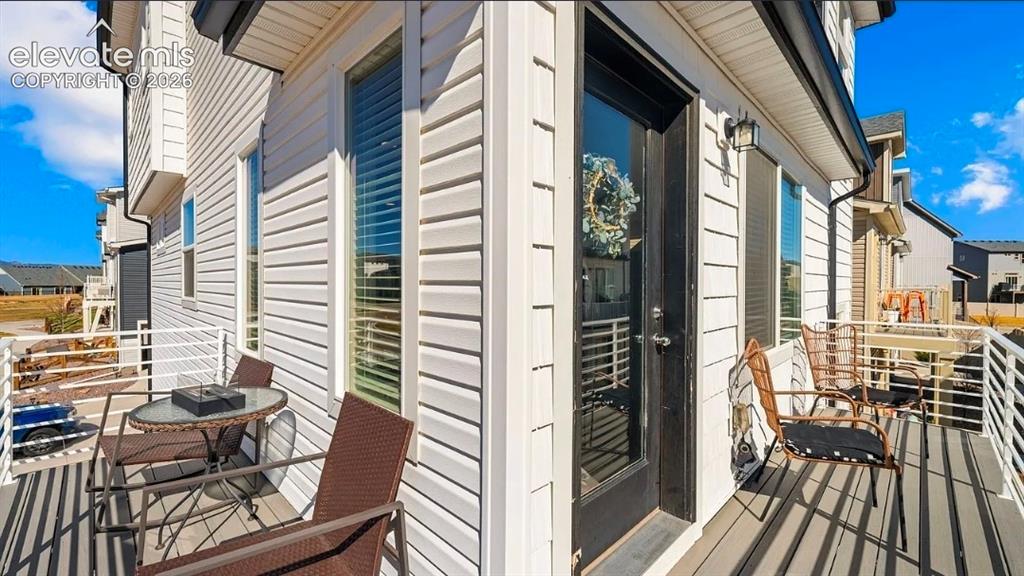 Image 21 of 22: Spacious composite deck with wood-finish flooring and black metal railings,