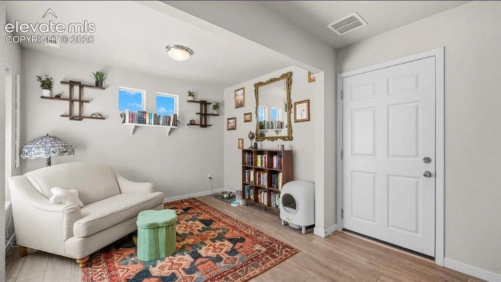 Image 5 of 22: Bright and versatile den featuring a wood-finish floor, large windows with 
