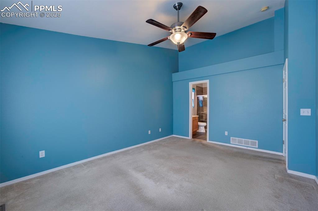Image 17 of 30: Ceiling Fan, carpet, walk in closet, adjoining bathroom