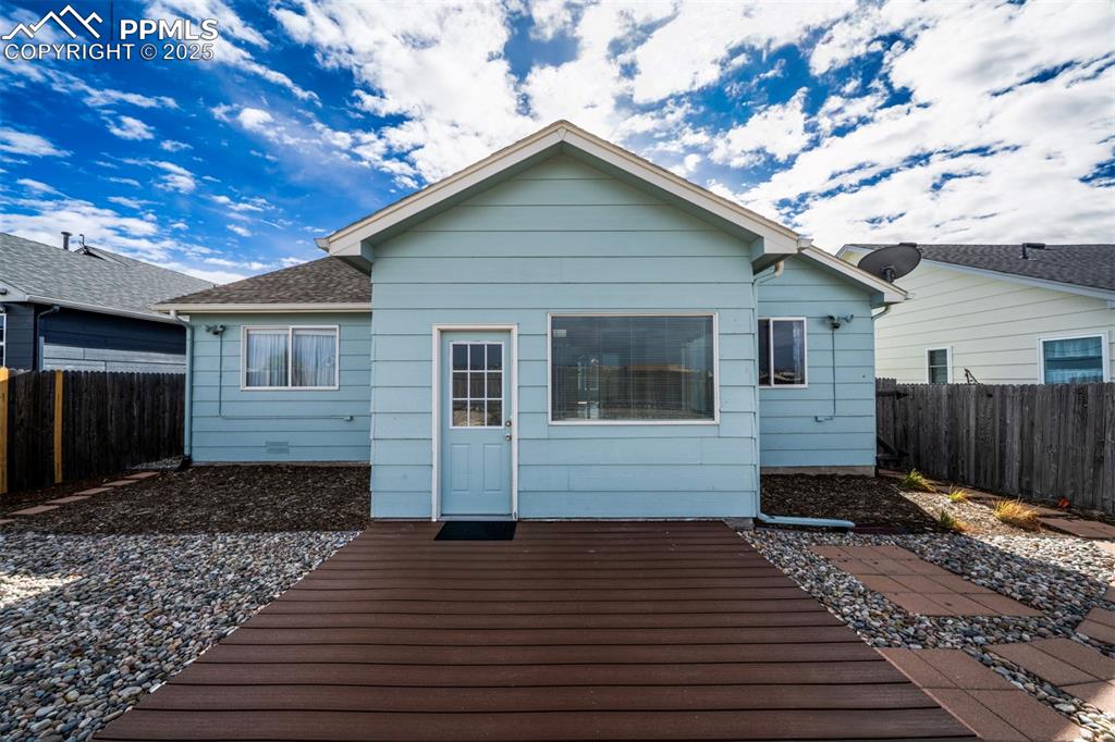 Image 27 of 30: Back of property featuring a fenced backyard and a wooden deck