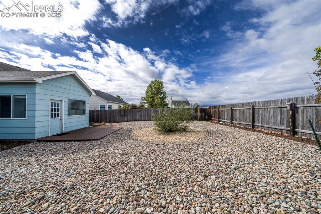 Image 28 of 30: Fenced backyard with a deck