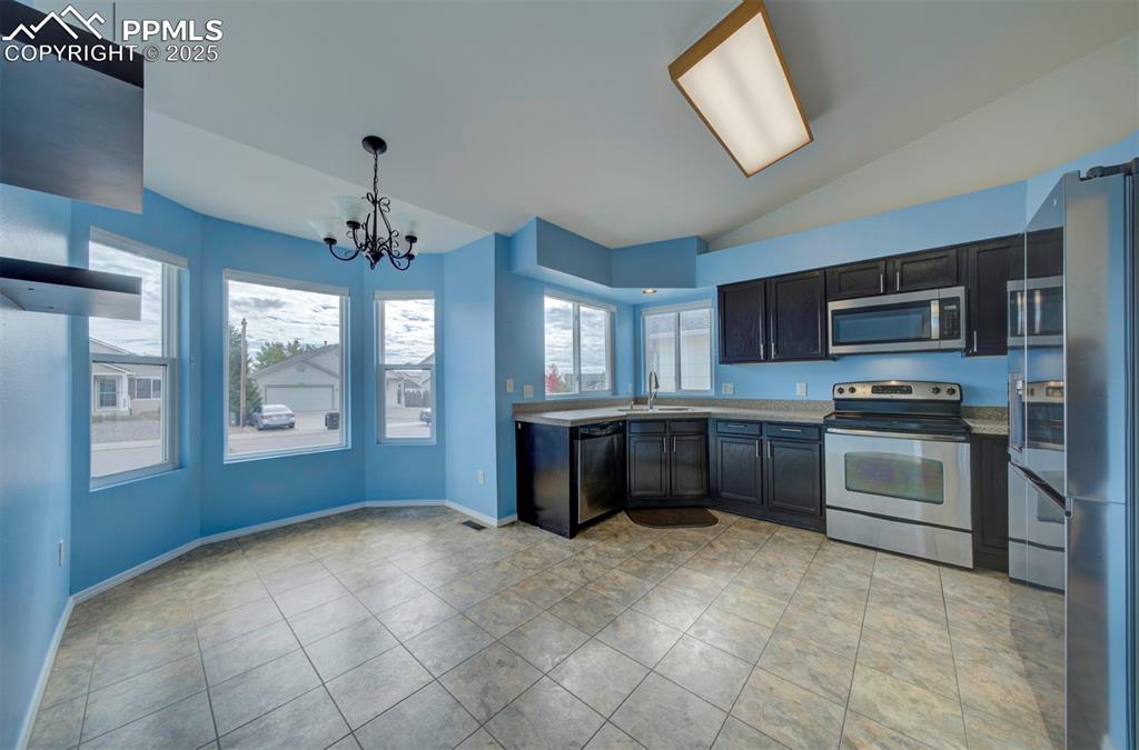 Image 5 of 30: Stainless steel appliances, granite counter tops, dark brown cabinets, pant