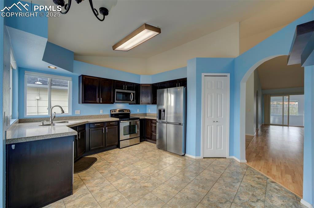 Image 7 of 30: Stainless steel appliances, granite counter tops, dark brown cabinets, pant