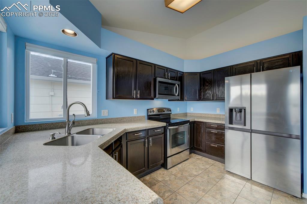 Image 8 of 30: Stainless steel appliances, granite counter tops, dark brown cabinets, pant