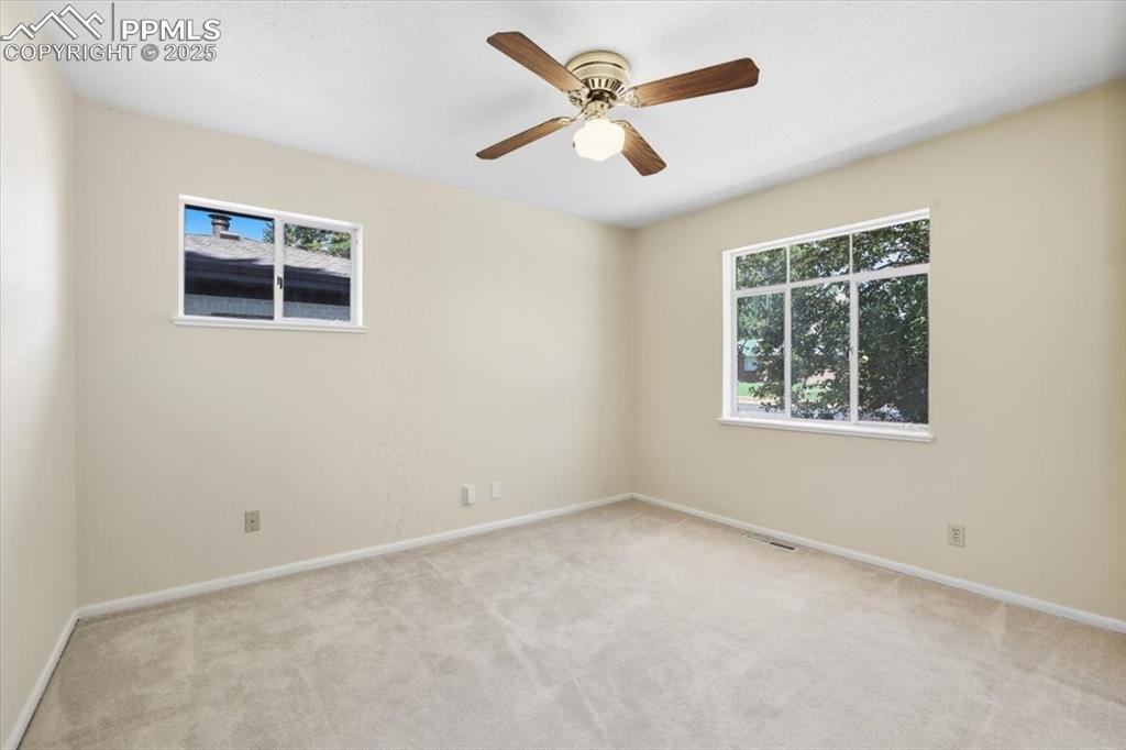 Image 12 of 30: Empty room featuring light colored carpet and a ceiling fan