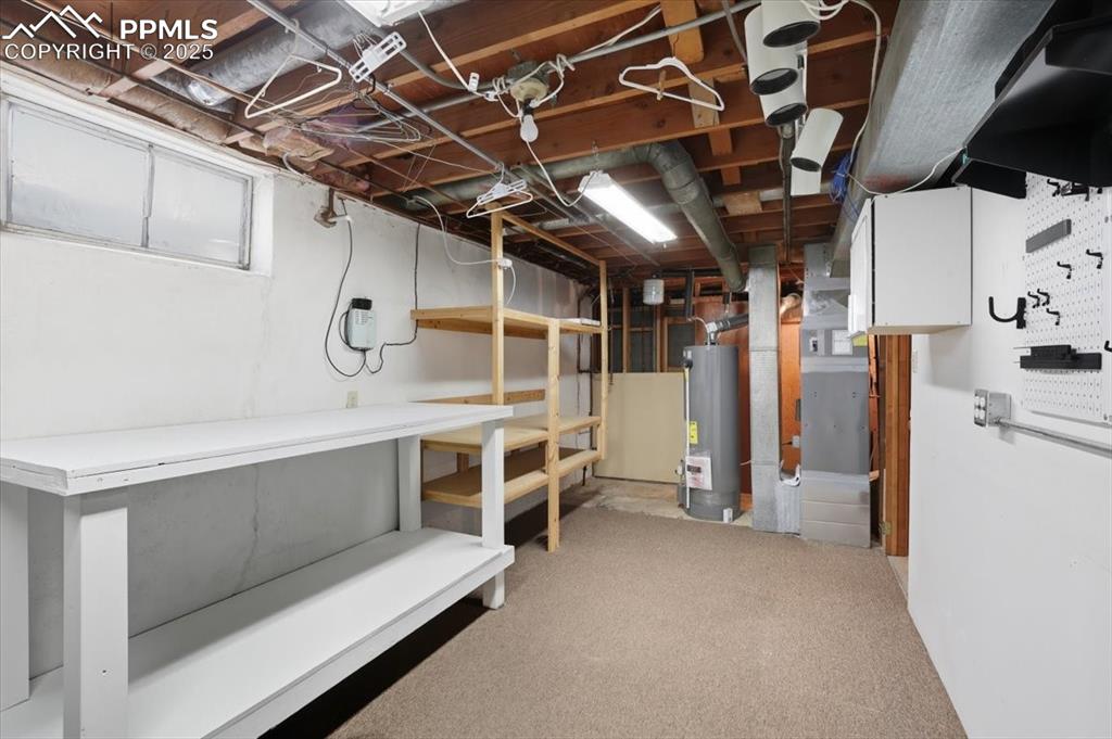 Image 16 of 30: Unfinished basement featuring light carpet, gas water heater, and heating u