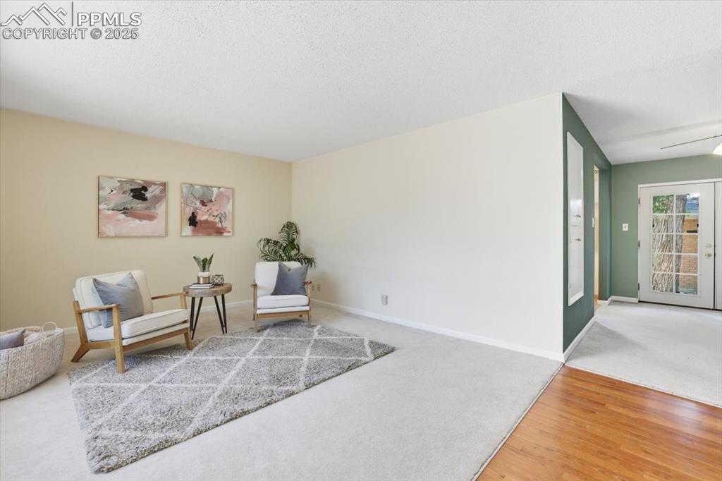 Image 2 of 30: Sitting room featuring carpet flooring, wood finished floors, and a texture