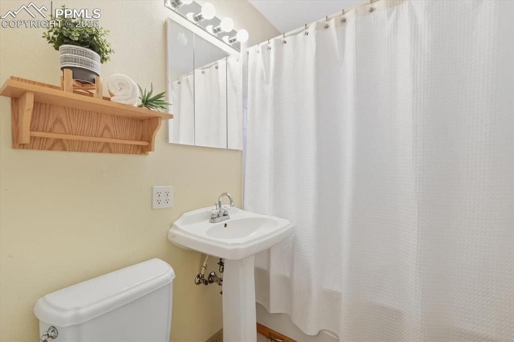 Image 9 of 30: Full bathroom featuring toilet and shower / bath combination with curtain
