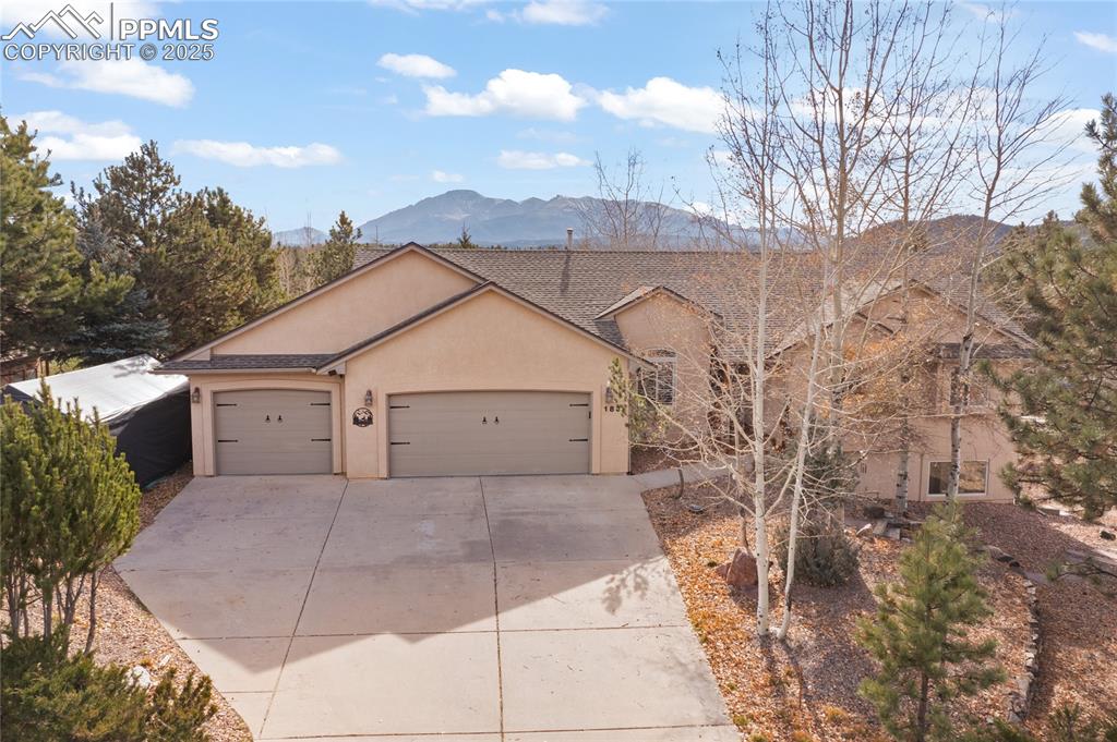 Caption: Plenty of parking at with the large driveway and three car garage. Durable stucco exterior. Heated g