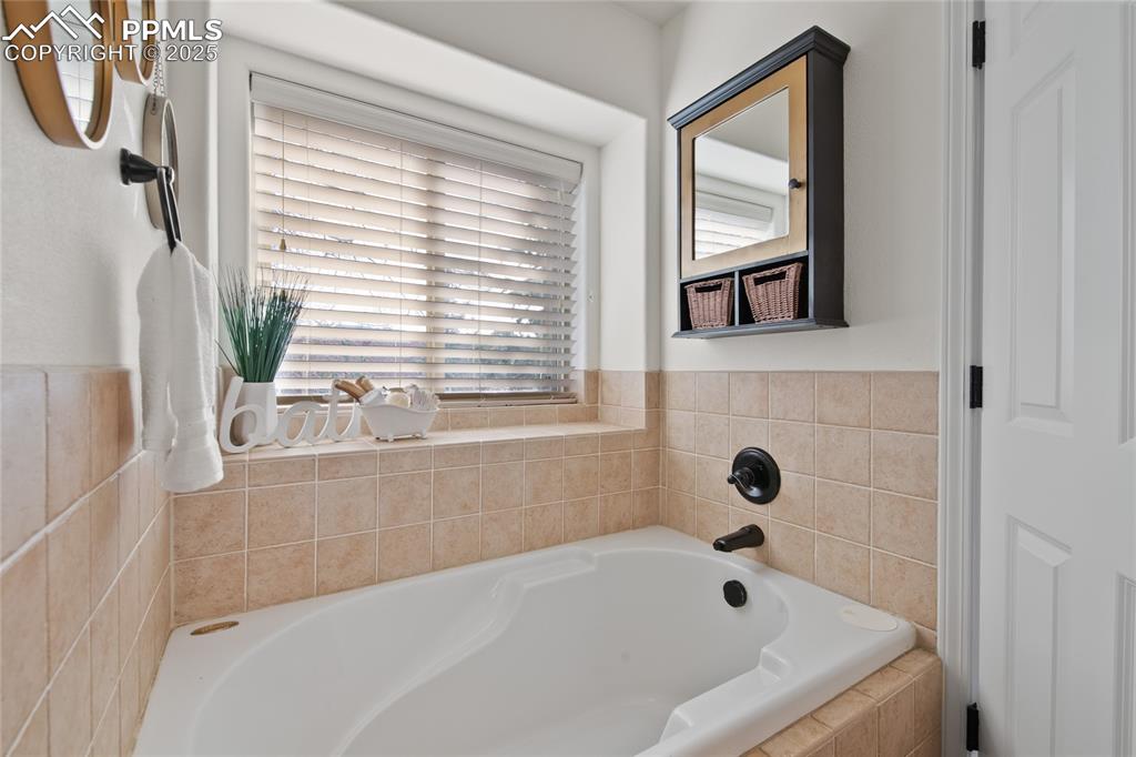 Image 28 of 50: Large soaker tub in the primary bathroom with Pikes Peak Views. 