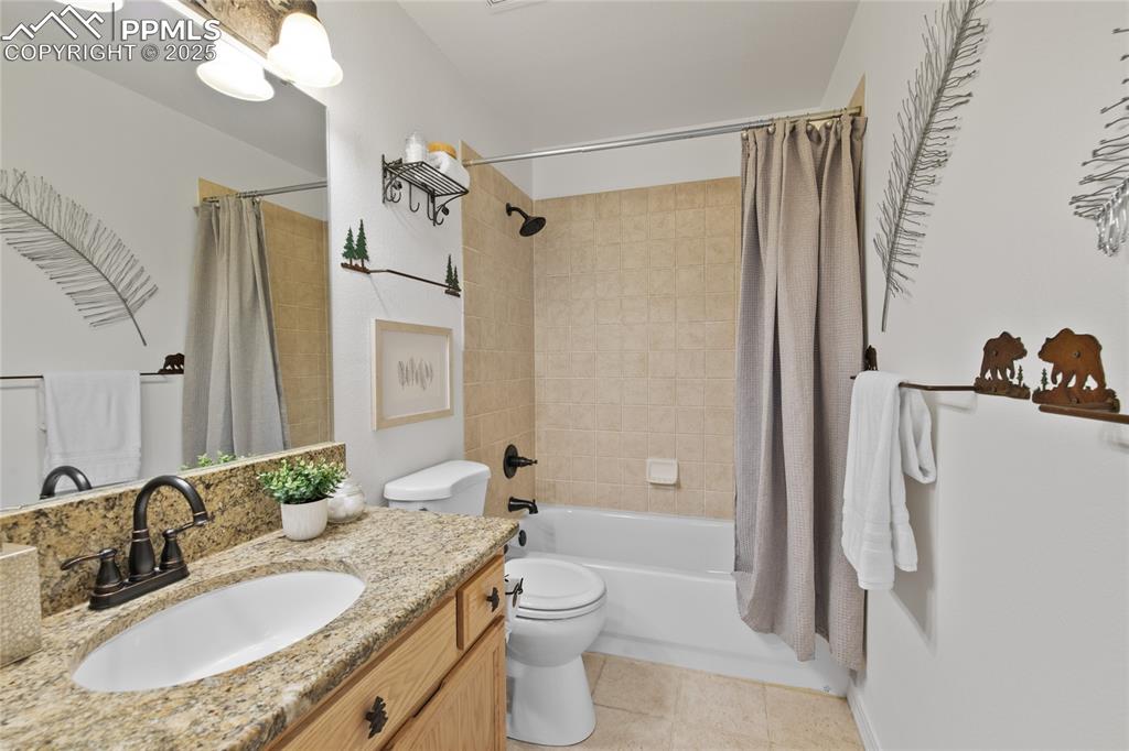 Image 29 of 50: Main level full bath has granite counters and cool decorative mountain feat