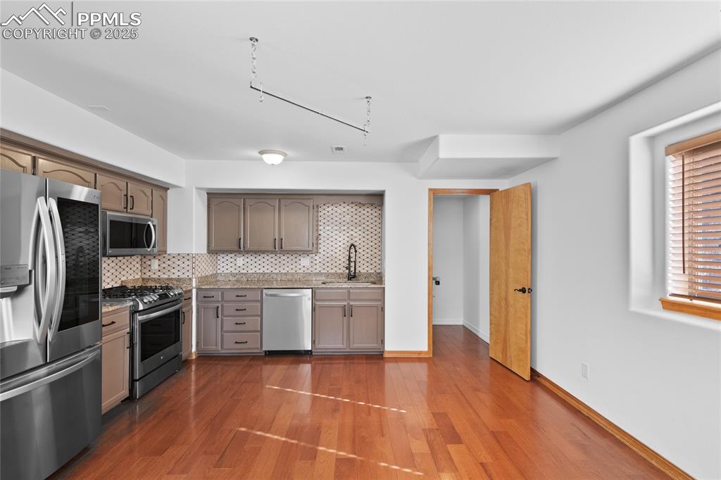 Image 38 of 50: Second full kitchen in the basement. Stainless appliances. Granite counters