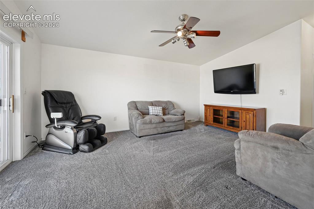 Image 18 of 50: Sliding glass door, wall-mounted television, wooden media console, and ceil