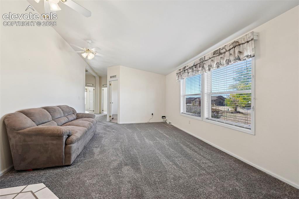 Image 26 of 50: Vaulted ceilings, dual ceiling fans, wall-to-wall carpeting, and expansive 