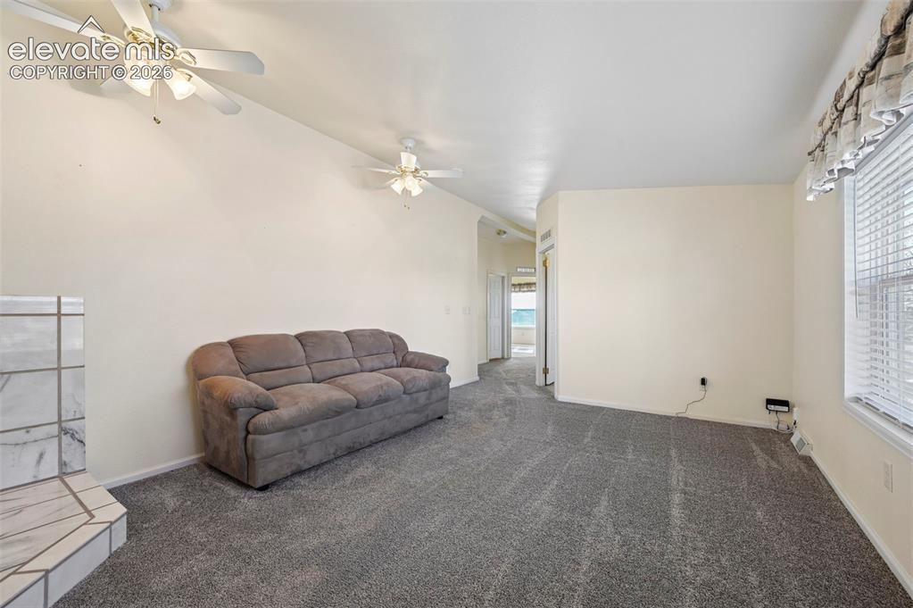 Image 27 of 50: Neutral-toned interior space featuring a stone-faced fireplace hearth, dual