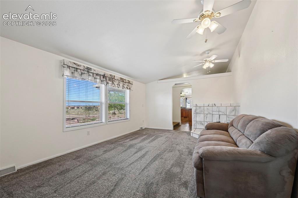 Image 29 of 50: Vaulted ceilings featuring dual ceiling fans, wall-to-wall carpeting, and a