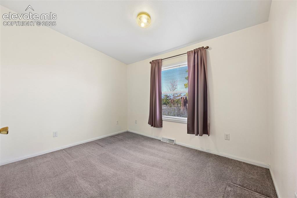 Image 30 of 50: Neutral-toned interior room featuring wall-to-wall carpeting and a single-h