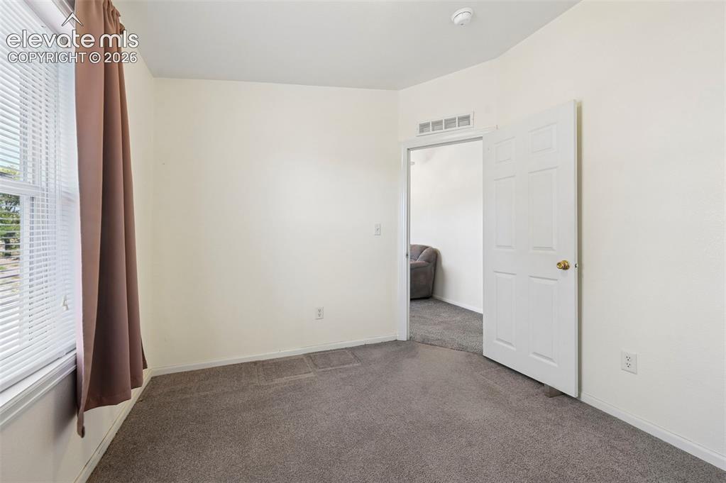 Image 31 of 50: Neutral interior featuring grey carpeting, off-white wall finishes, and a s