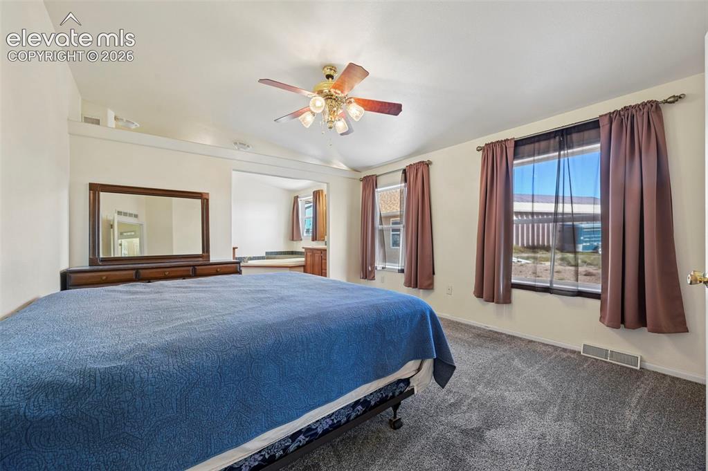 Image 37 of 50: Bedroom featuring a vaulted ceiling with a four-light brass finish ceiling
