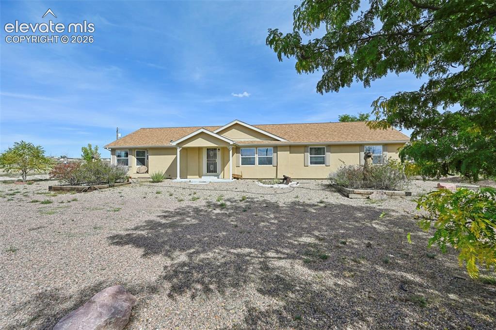 Image 4 of 50: Single-story residence with a covered entryway, neutral stucco siding, and