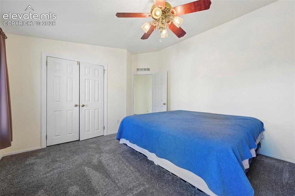 Image 40 of 50: Neutral-toned wall finish, wall-to-wall carpeting, ceiling fan with integra