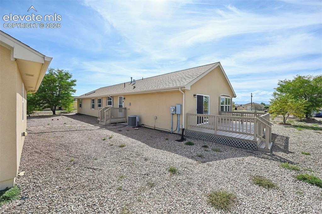 Image 5 of 50: Stucco exterior featuring a raised wooden deck with lattice skirting and xe