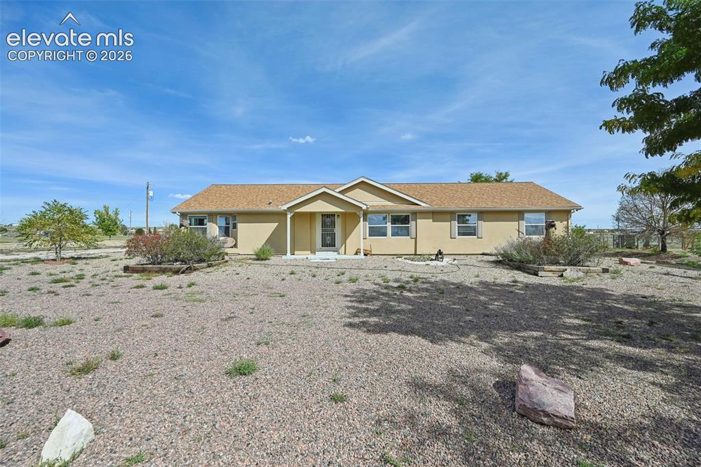 Image 6 of 50: Single-story ranch-style exterior featuring a neutral stucco facade, gabled