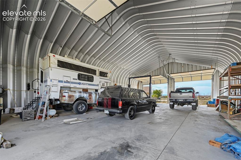 Image 9 of 50: Spacious metal Quonset-style structure featuring a high-clearance arched ce