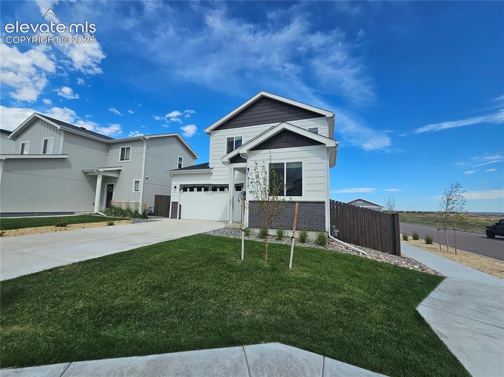 Image 1 of 35: Two-story residence featuring a two-car garage, white siding, dark shingle