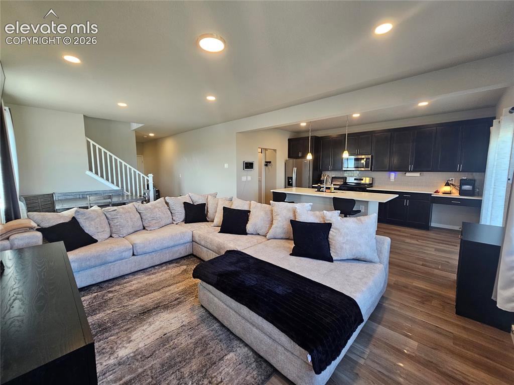 Image 11 of 35: Open-concept floorplan with recessed lighting, wood-finish flooring, and a 