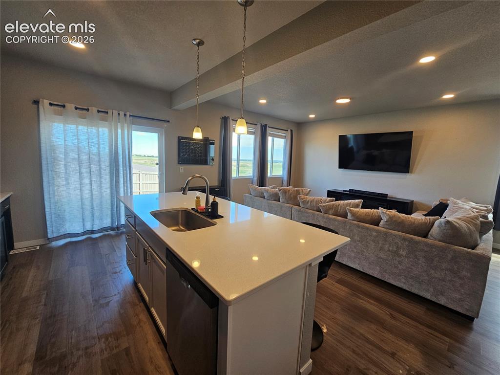 Image 12 of 35: Open concept living area with recessed lighting, wood-finish flooring, and