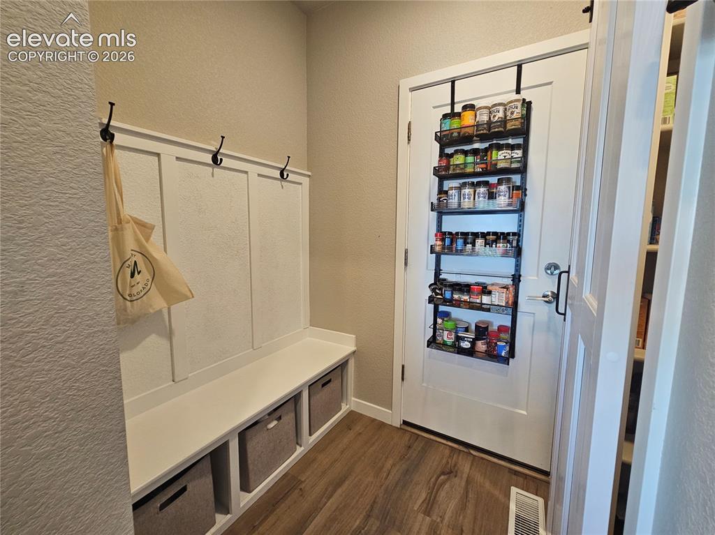Image 17 of 35: Built-in bench with storage cubbies and wall hooks