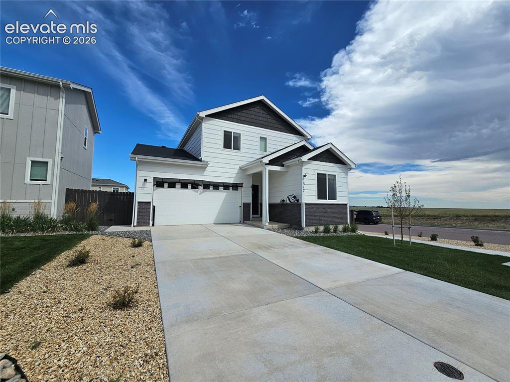 Image 2 of 35: Contemporary two-story residence featuring a two-car garage, white siding, 