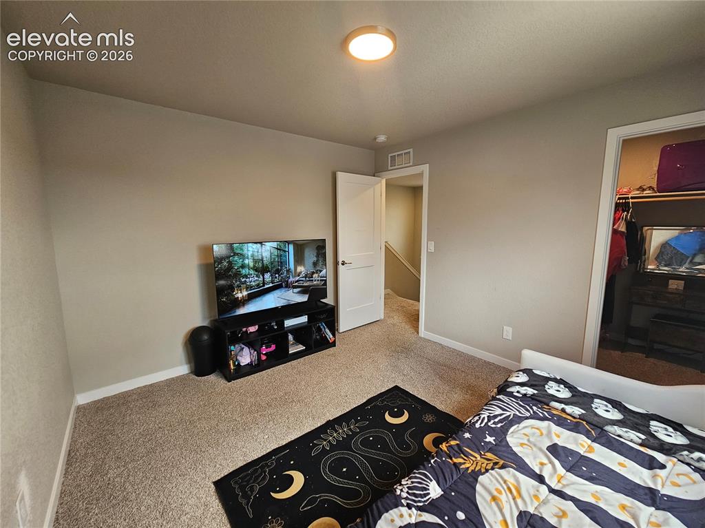 Image 20 of 35: Wall-to-wall carpeting with light neutral walls, a white interior door, and