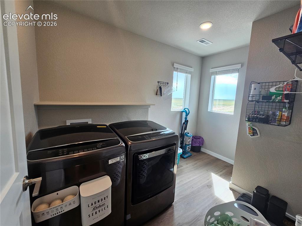 Image 22 of 35: Dedicated laundry area featuring a built-in shelf, two windows, and wood-fi