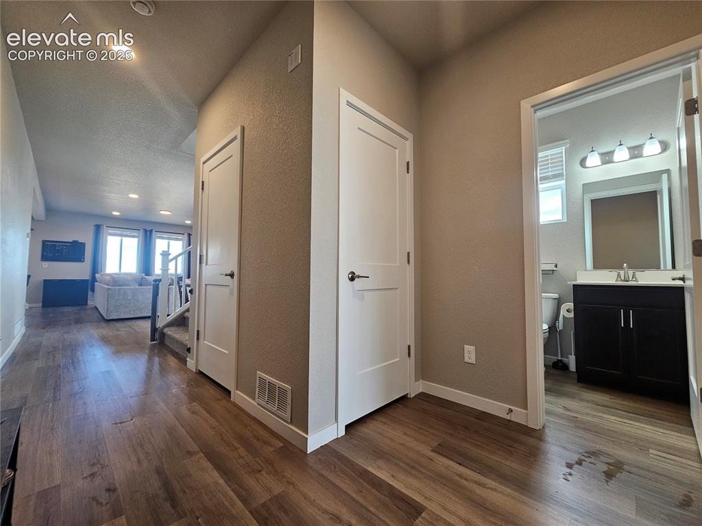 Image 4 of 35: Wood-finish flooring throughout, recessed lighting, and a bathroom featurin