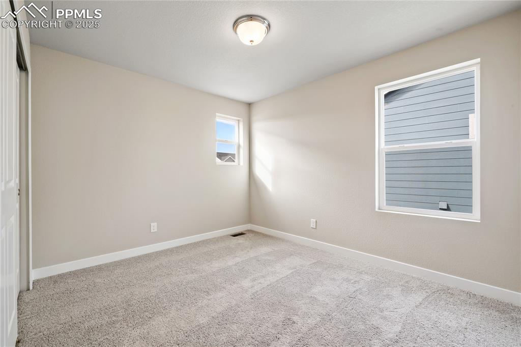 Image 20 of 25: Carpeted spare room featuring baseboards