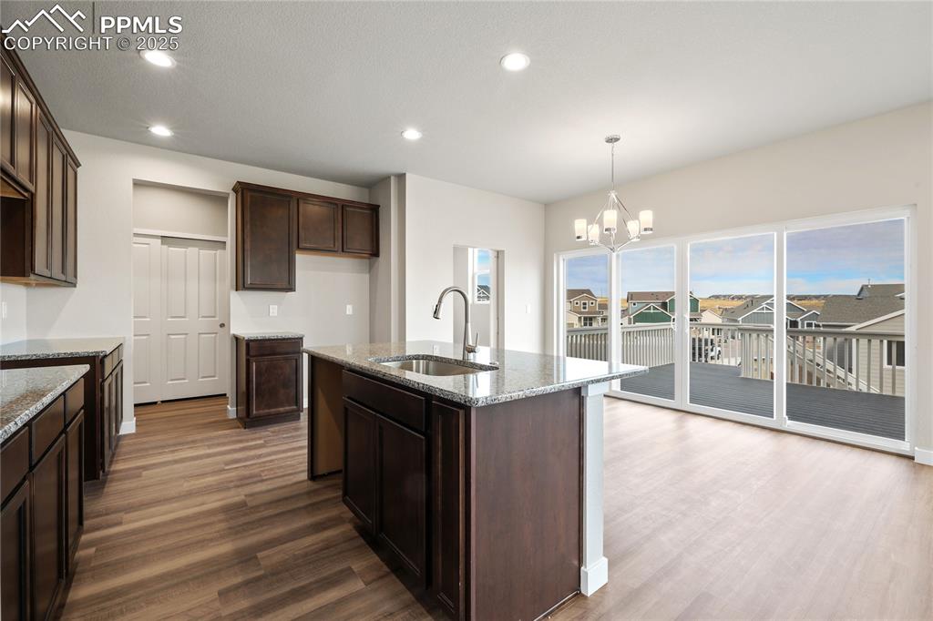 Image 9 of 25: Kitchen featuring recessed lighting, dark brown cabinetry, and a chandelier